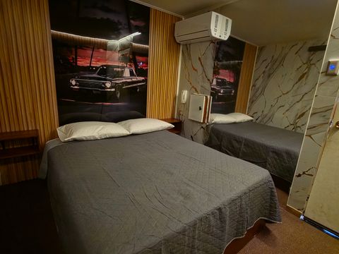 Habitación climatizada de Motel Match con cama de 2 plazas y mural de auto clásico