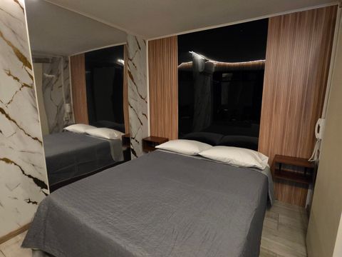 Habitación de Motel Match con piso de madera, espejo y velador
